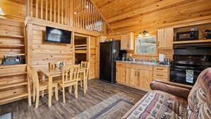 L’intérieur d’un chalet en bois comprend un coin repas, une cuisine et un espace salon confortable.