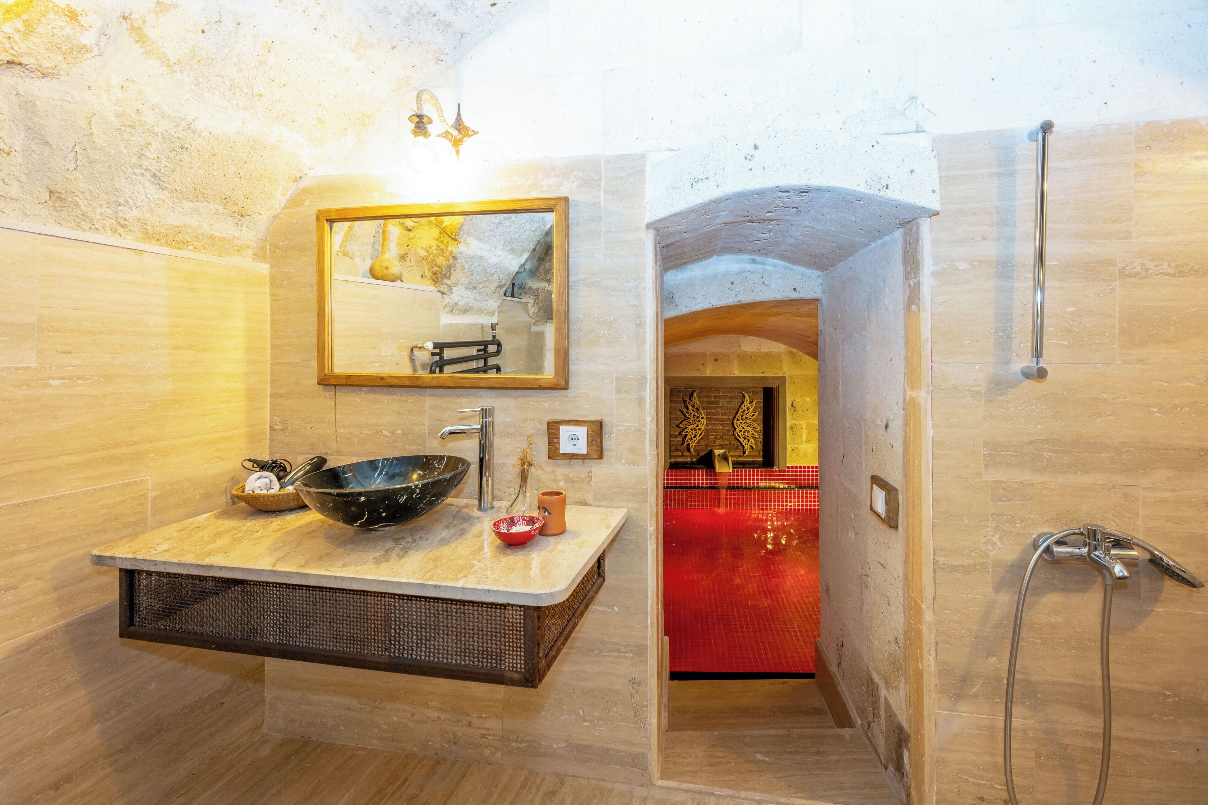 A bathroom with a large sink, mirror, and shower.
