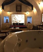 Una habitación acogedora con una bañera grande, un sofá y una mesa de comedor.