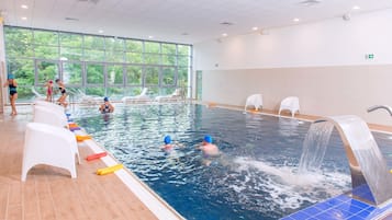 Una piscina techada, sillones reclinables de piscina