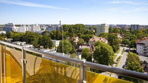 Une vue urbaine avec des immeubles résidentiels, un ciel dégagé et une barrière de sécurité jaune.