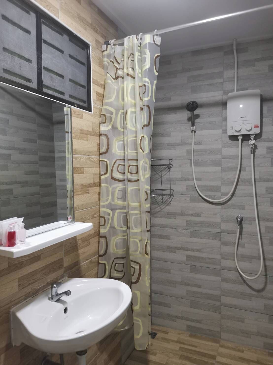 A bathroom with a shower, a sink, and a toilet.