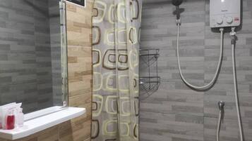 A bathroom with a shower, a sink, and a toilet.