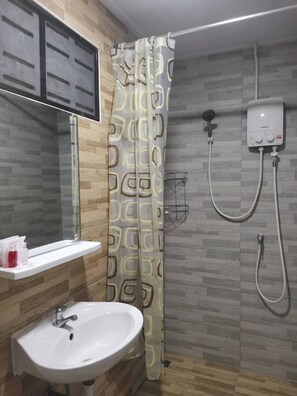 A bathroom with a shower, a sink, and a toilet. - Numhom Resort (Thap Than)