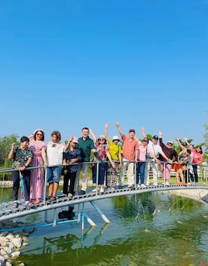 A group of people standing on a bridge over a body of water. - Numhom Resort (Thap Than)