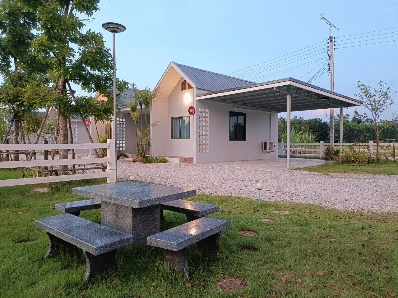 A house with a covered patio, a gravel driveway, and a picnic table.