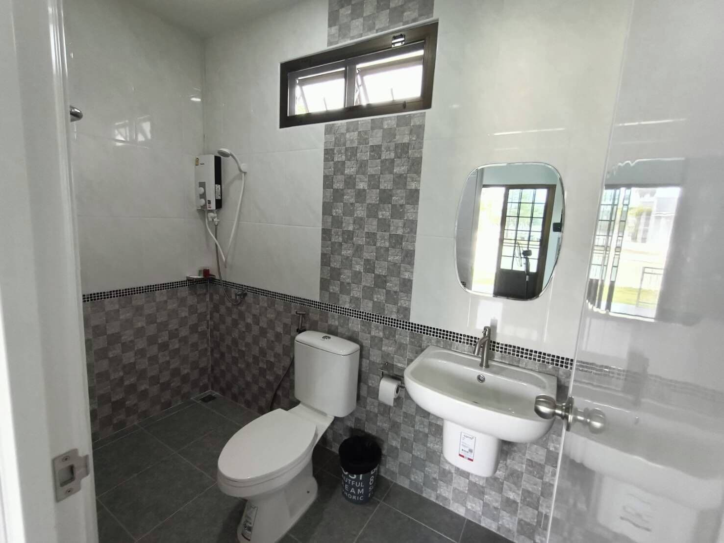 Un baño con inodoro, lavamanos y ducha.