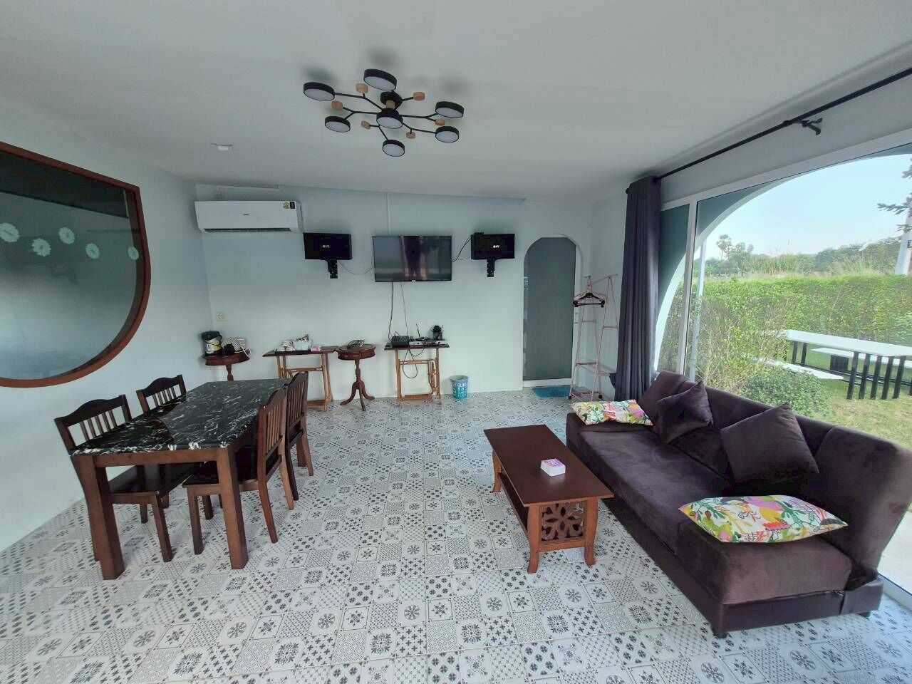Una sala de estar con una mesa de comedor, sofá y un ventanal grande.
