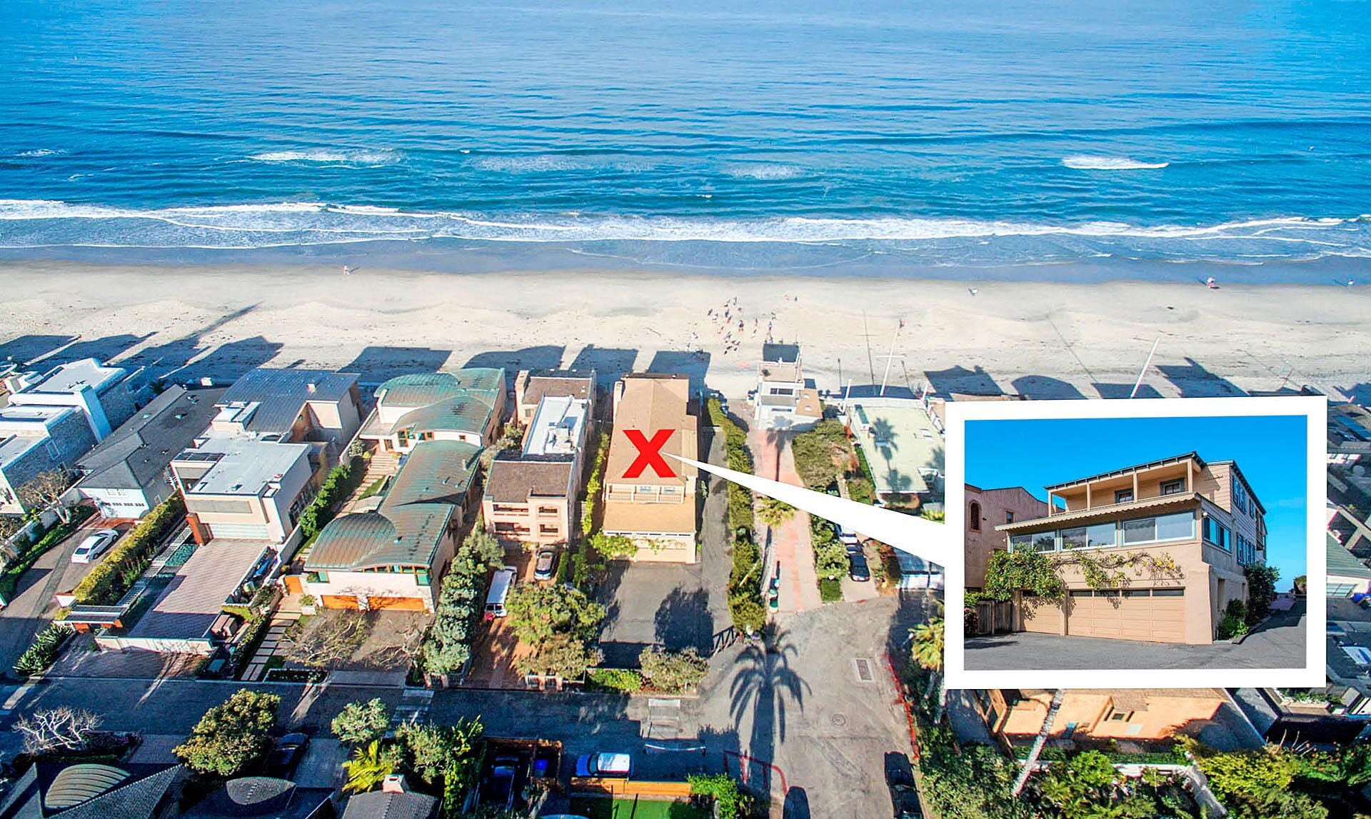 Vista aérea de una zona residencial costera con una playa al fondo.