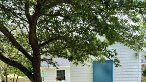 A white picket fence with a sign reading "Elemon's Cottage" and a website address.