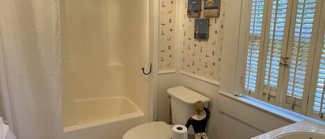 A bathroom with a bathtub, toilet, and sink.