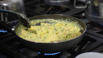 Une poêle sur une cuisinière, dans laquelle un mélange est en train d’être remué.