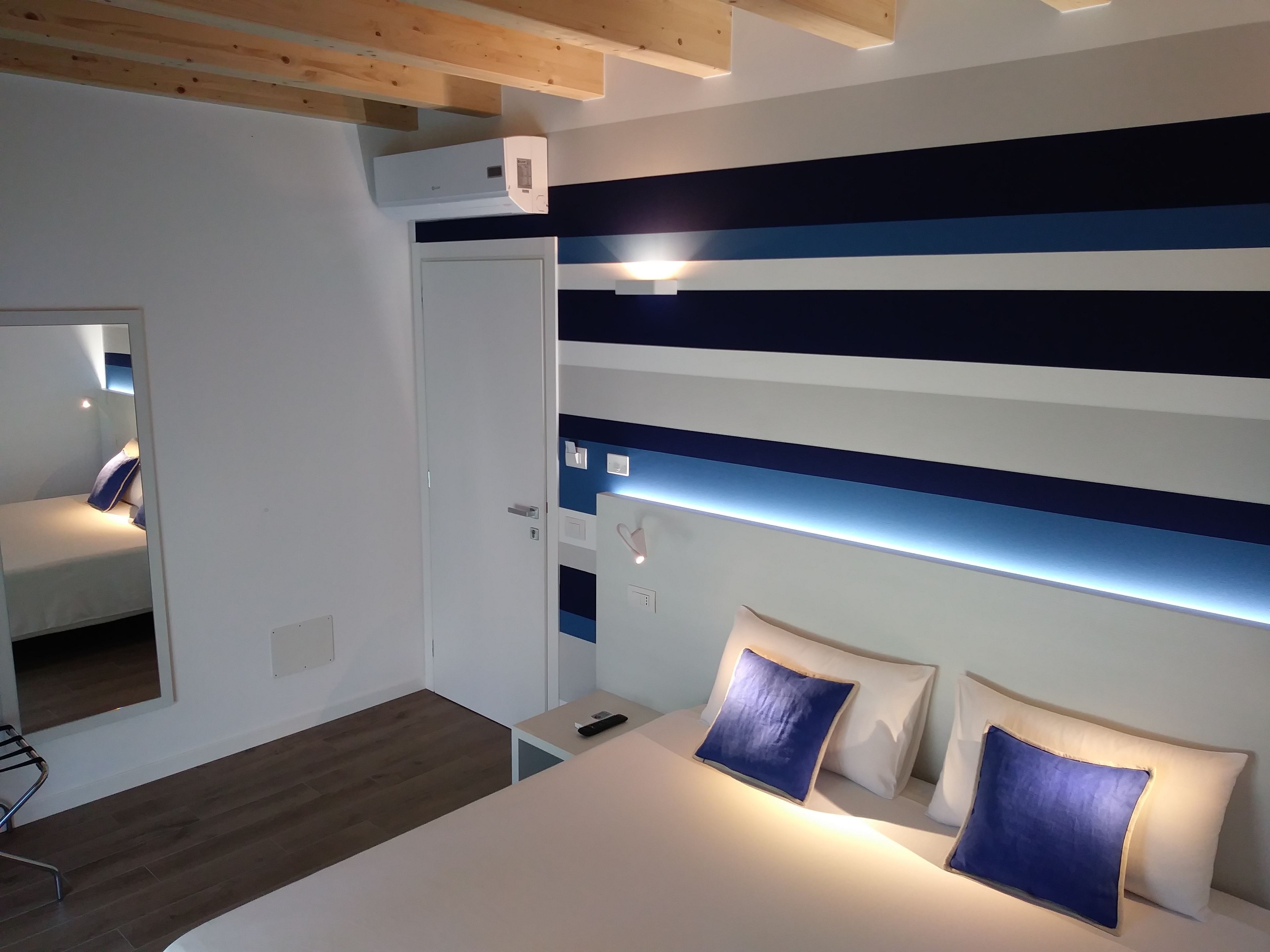 Une chambre à coucher moderne avec un lit, des tables de chevet et un miroir.