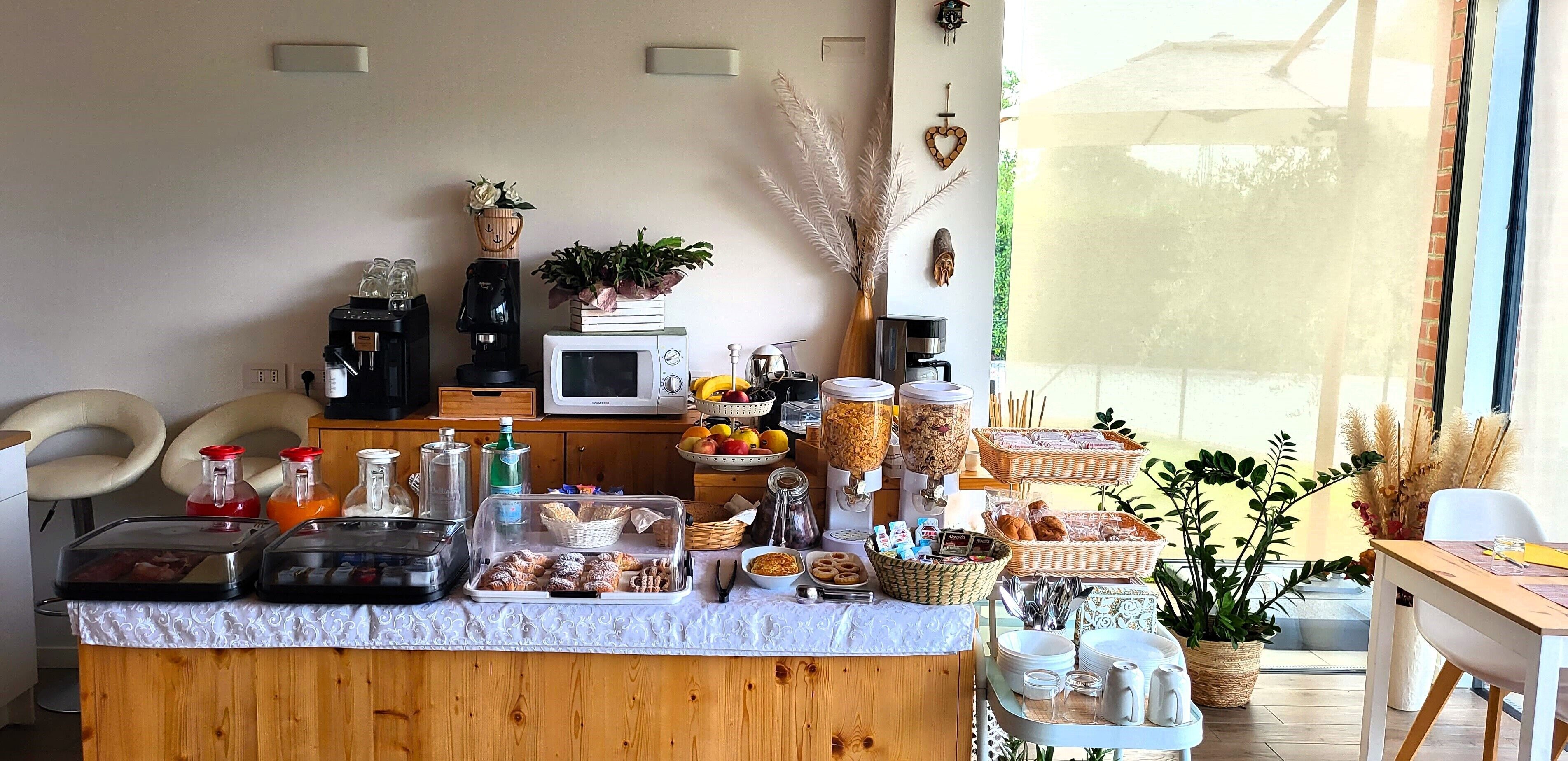 Ein reichhaltiges Frühstücksbuffet mit verschiedenen Speisen, einer Mikrowelle und einer Kaffeestation.