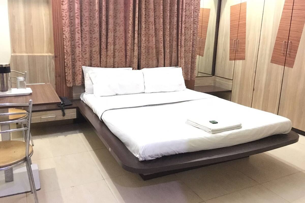 Een moderne hotelkamer met een bed, een bureau en een stoel.