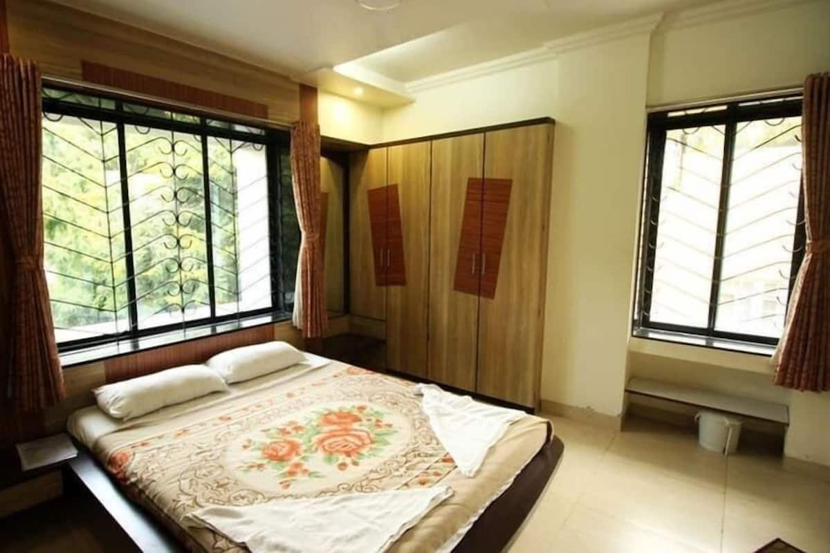 Een slaapkamer met een bed, een kledingkast en ramen.