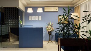 Een receptie met een blauw aanrecht, een trap en potplanten.