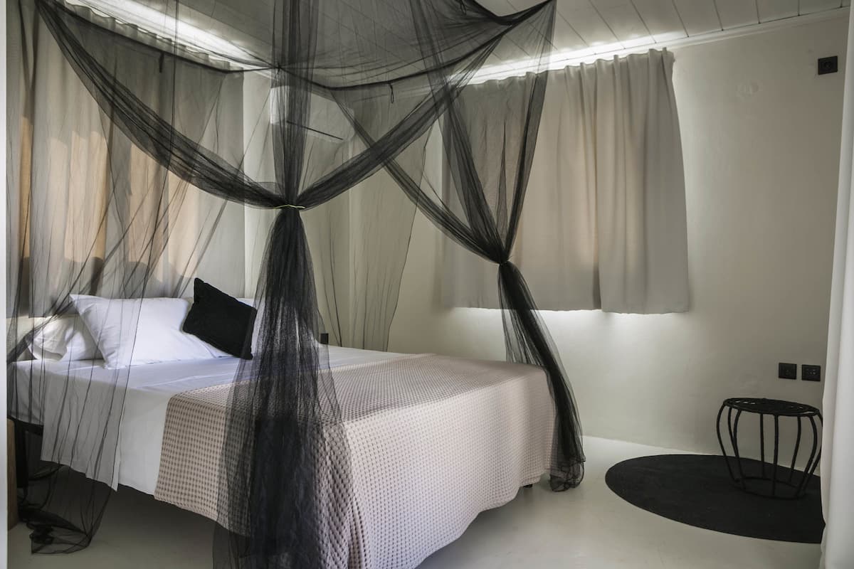 Ein Schlafzimmer mit einem Bett, einem Nachttisch und einem kleinen runden Tisch.