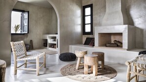 Een moderne woonkamer met een open haard, houten meubels en een groot rondboogvenster.