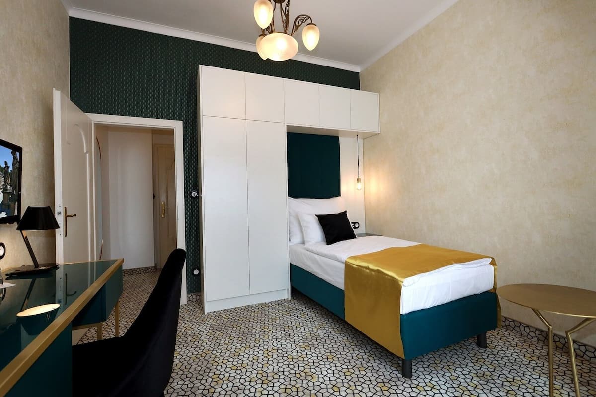 Ein Hotelzimmer mit einem Bett, einem Schreibtisch, einem Stuhl und einem Kleiderschrank.