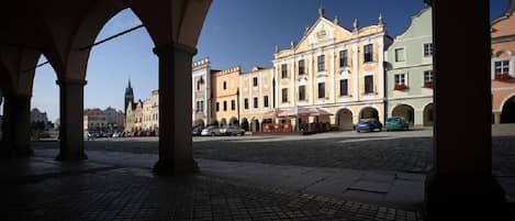 Un patio descubierto con suelo adoquinado, rodeado de edificios históricos de arquitectura clásica.