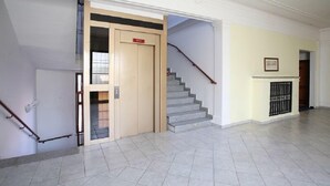A spacious hallway with a wooden door, a staircase, and a tiled floor. - Hotel U Černého orla (Telc)