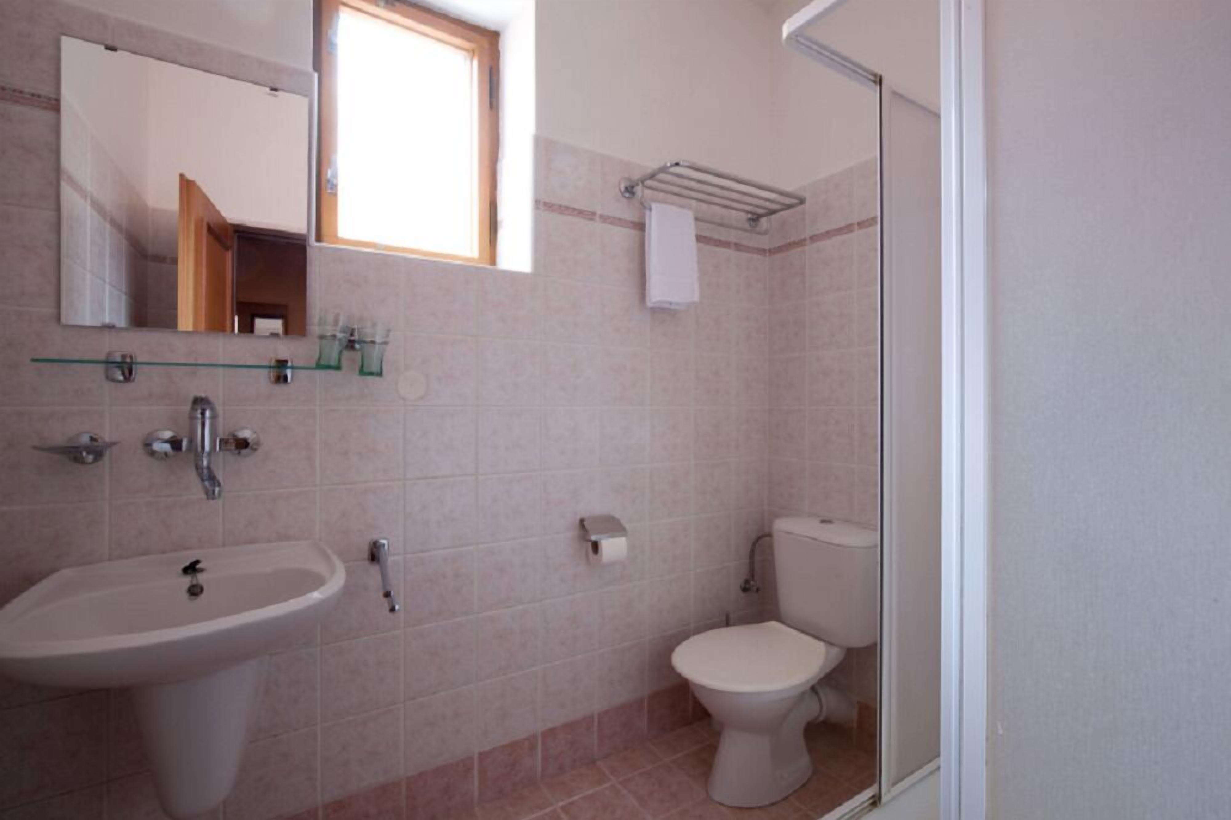 A bathroom with a sink, toilet, and a glass shower enclosure.