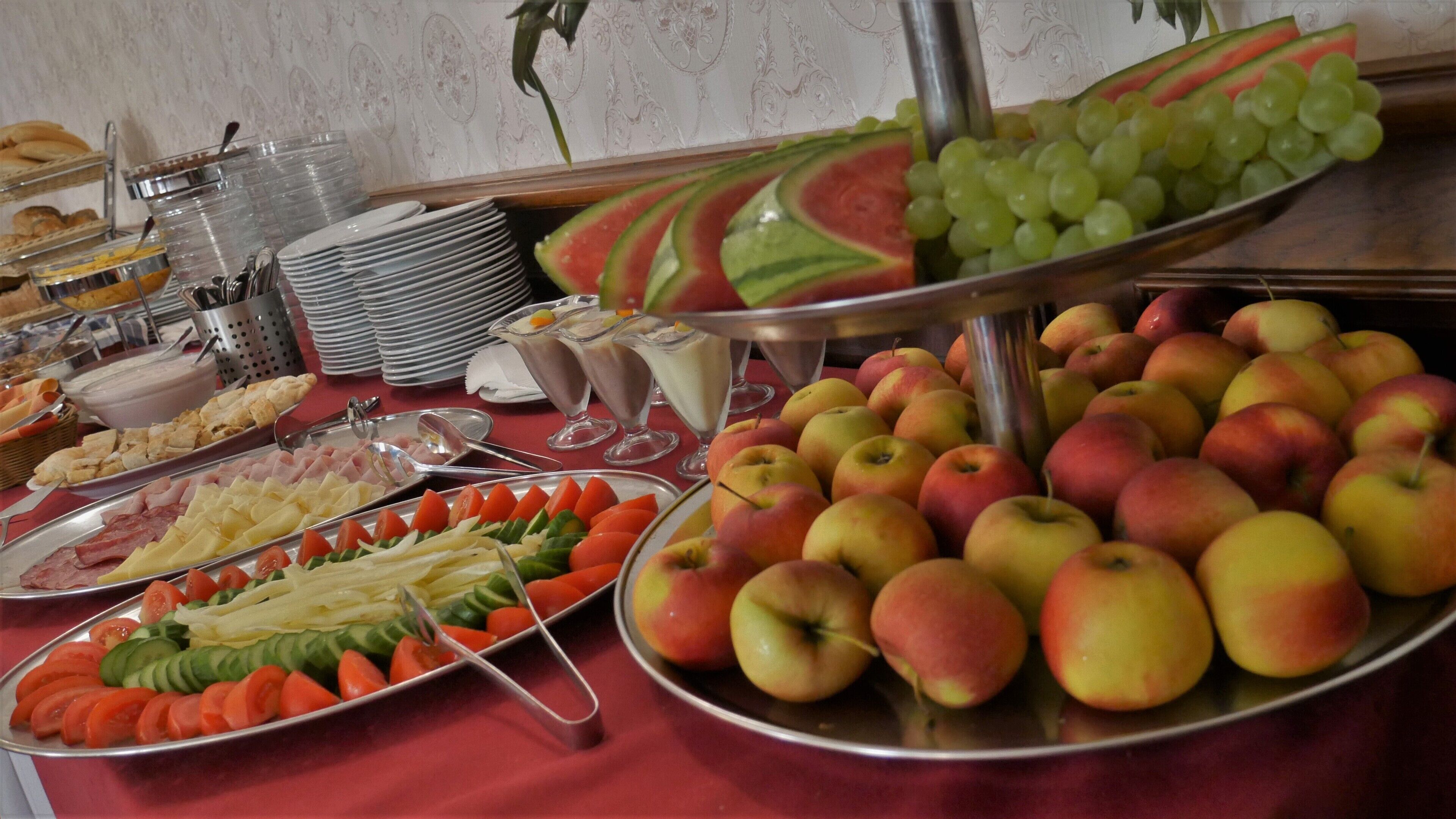 A buffet with various food items including fruits, vegetables, and desserts.