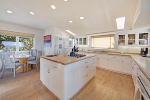 Enjoy meals in the kitchen with a central island, gas stove, and dining area with a glass table.