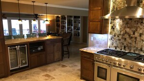 A modern kitchen with a central island, stainless steel appliances, and a decorative backsplash.