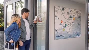 Una pareja parada frente a una puerta de vidrio con un mapa en la pared.
