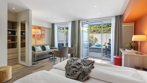 Una habitación de hotel moderna con cama, sofá, escritorio y vistas al exterior.