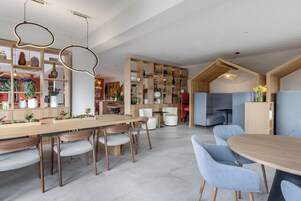 Un interior moderno con una mesa de comedor de madera, sillas y una estantería empotrada.