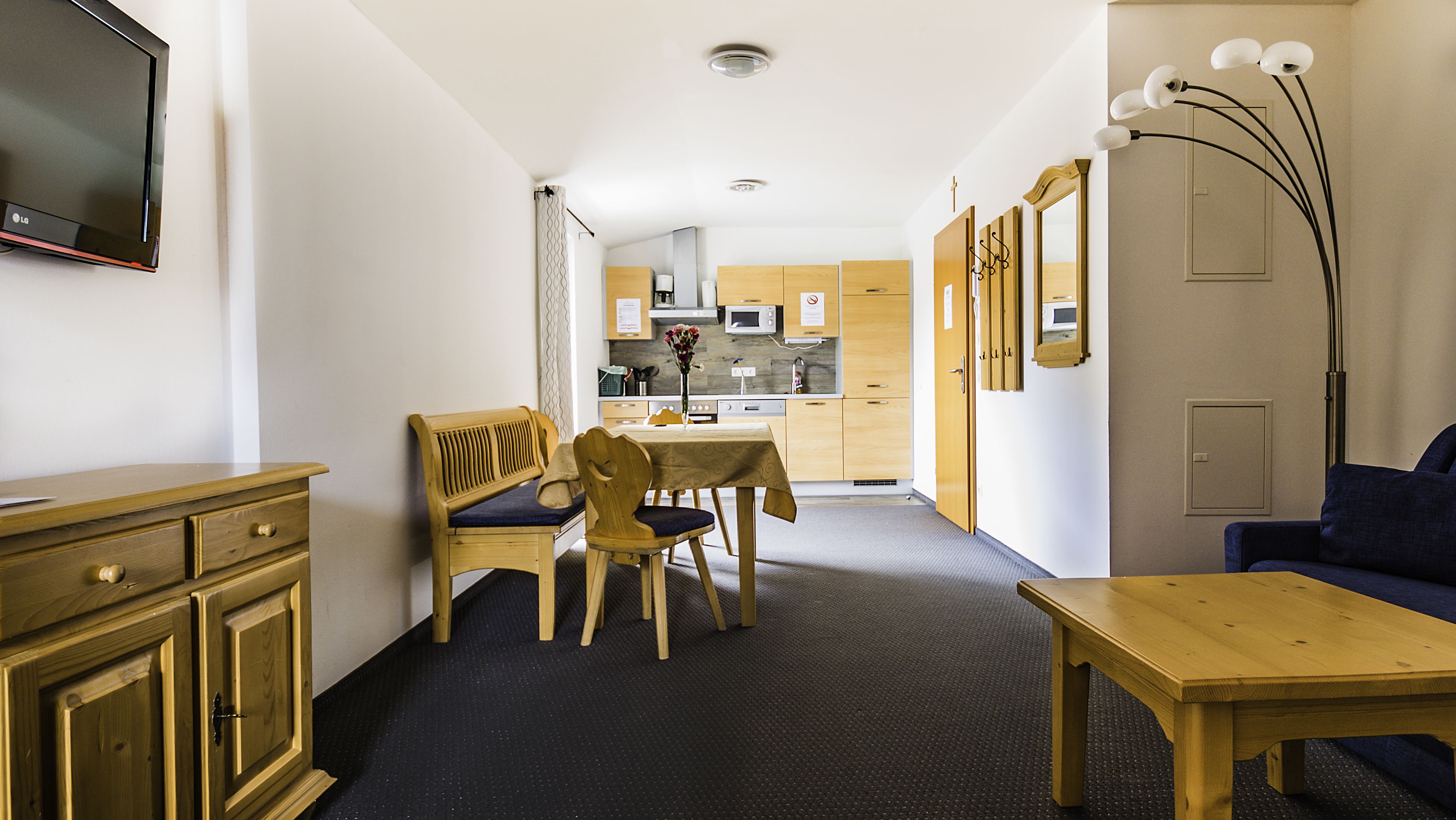 A compact living space with a dining area, kitchenette, and seating area.