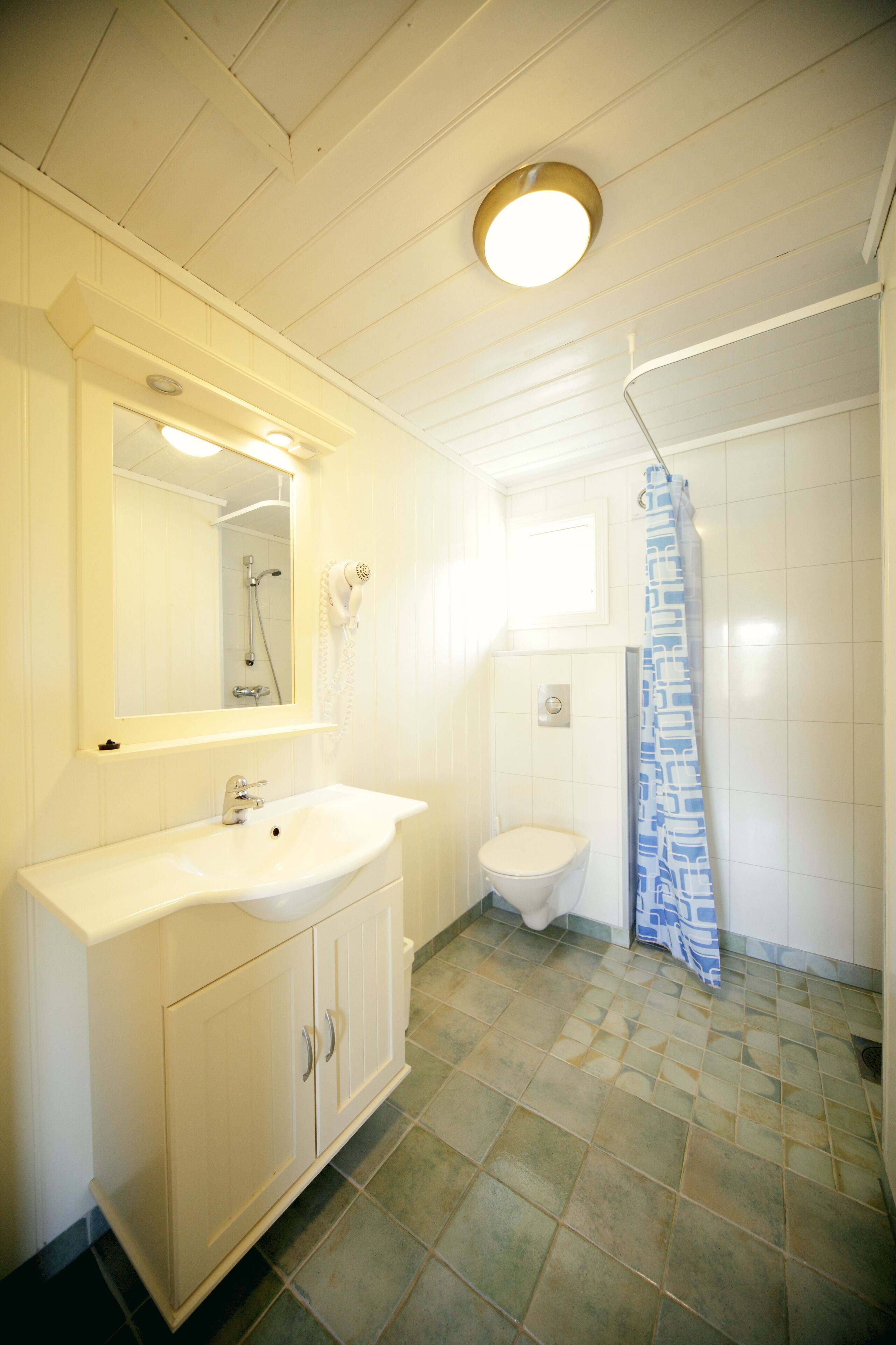 A bathroom with a white sink, mirror, and toilet.
