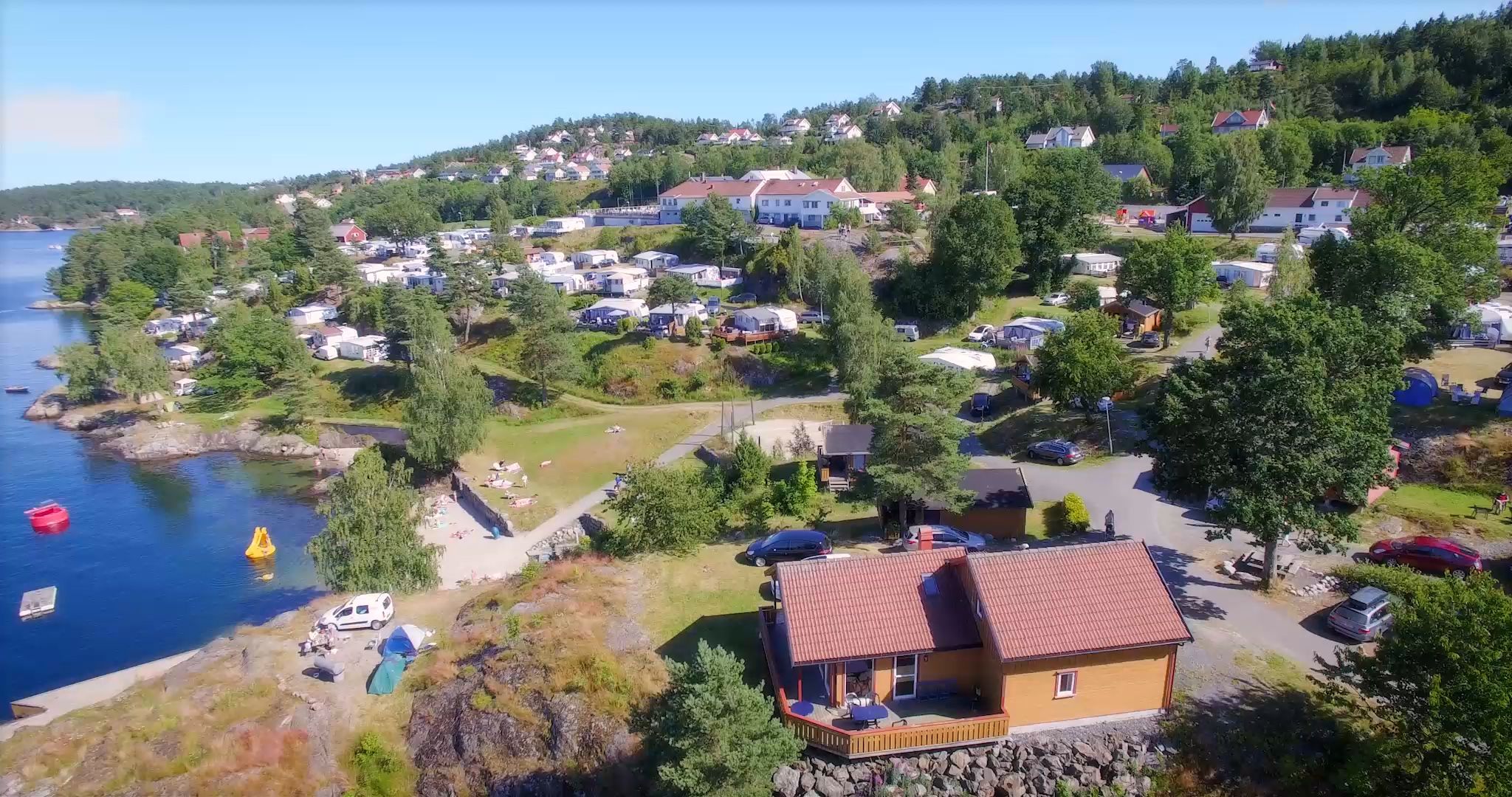 A coastal residential area with houses, a dock, and a small boat.