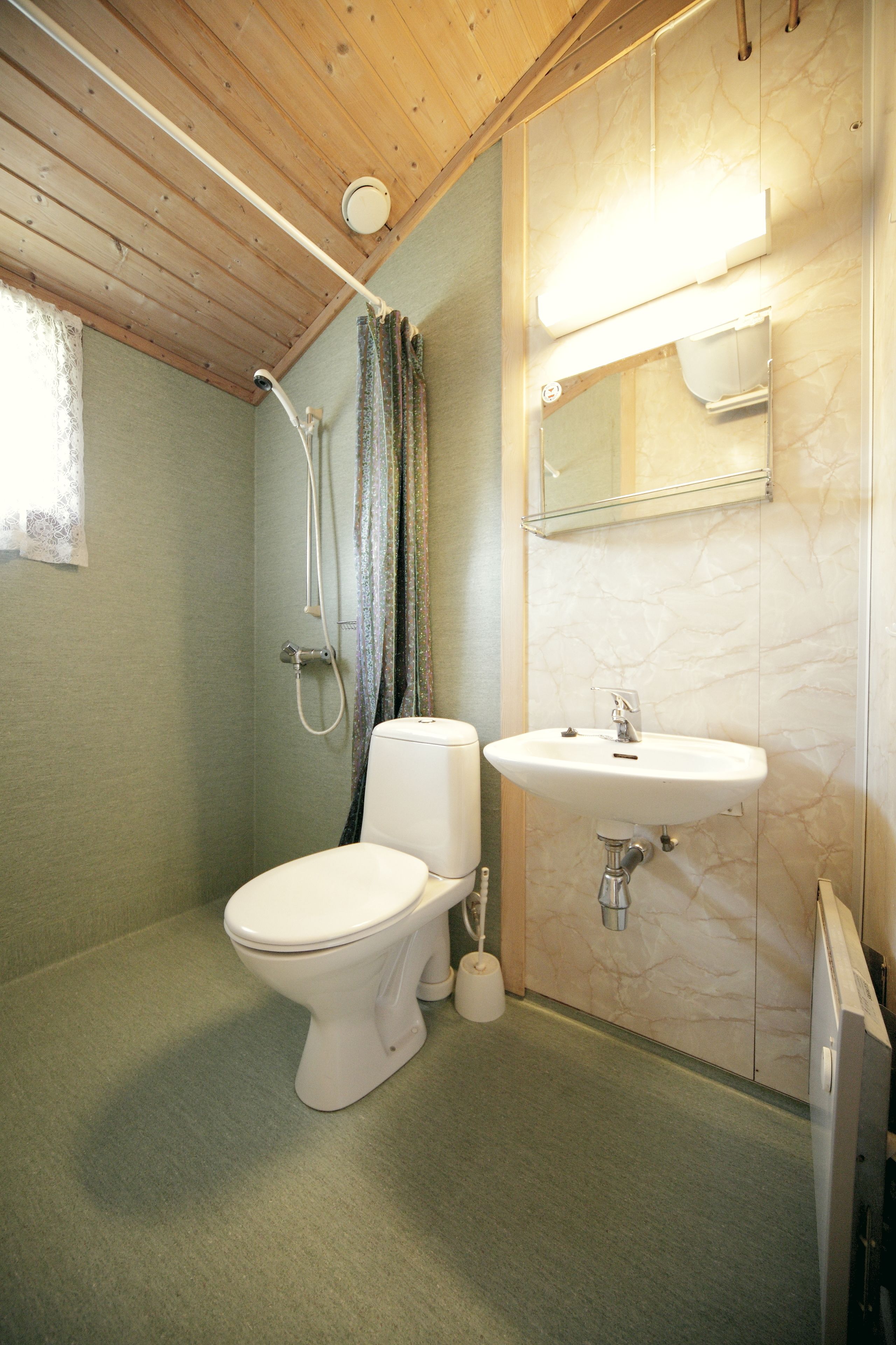 A bathroom with a toilet, a sink, and a shower.
