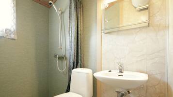 A bathroom with a toilet, a sink, and a shower.