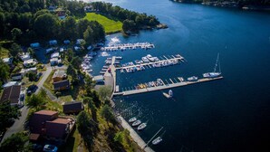 An aerial view of a marina with boats docked, surrounded by greenery and hills. - Sørlandet Feriesenter (Risør)