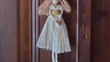 A wooden door with a hanging ornament featuring a figure in a dress and a sign that reads "Hattice Sulten".