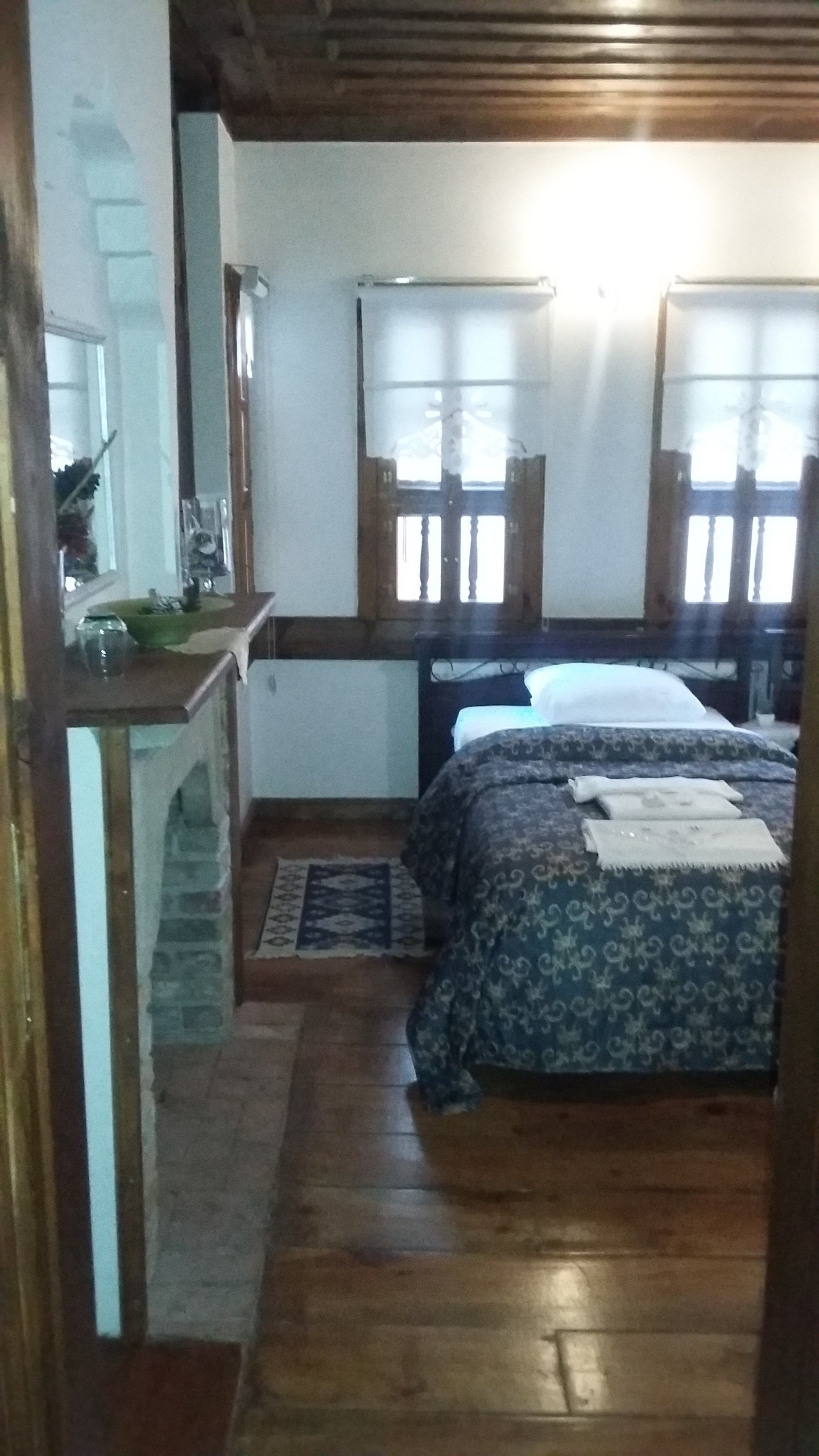 A bedroom with a bed, a dresser, a mirror, and a window.