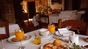 A breakfast setting with a table set for two, featuring orange juice, coffee, pastries, and fresh fruit. - Finca El Cabezo (Villamiel)