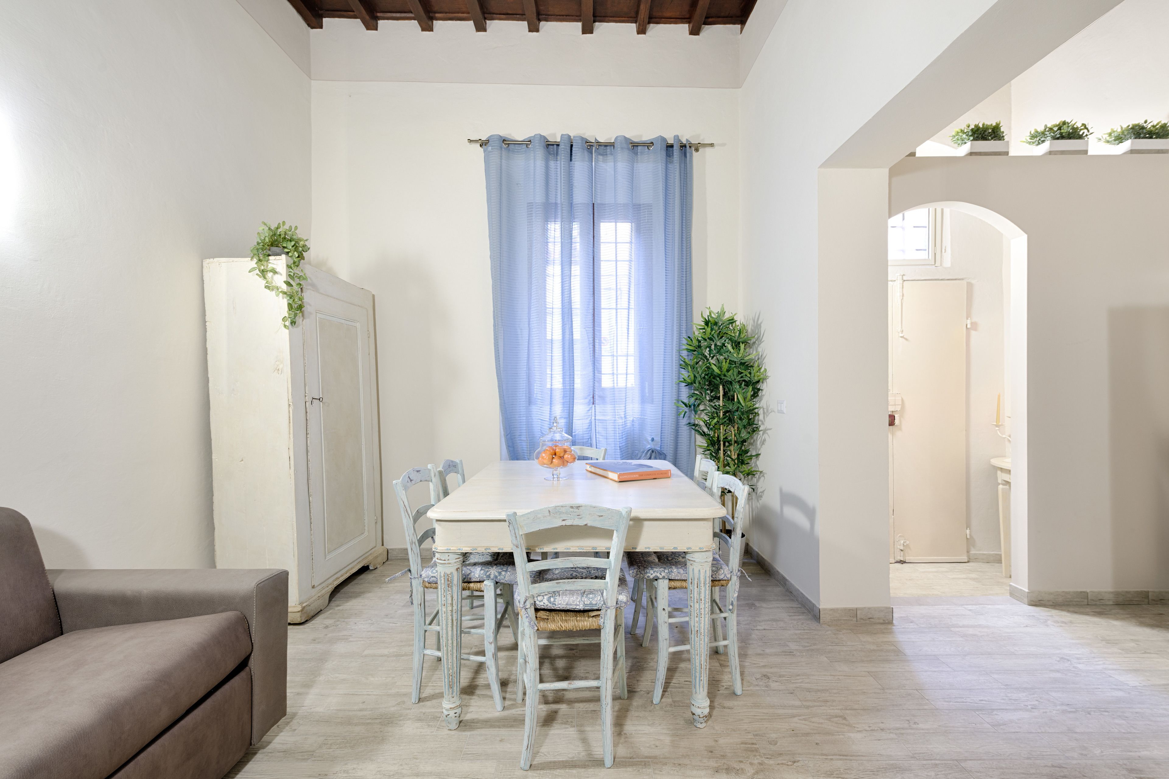 A dining area with a table, chairs, and a cabinet.