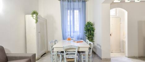 A dining area with a table, chairs, and a cabinet.