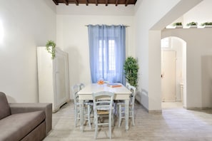 A dining area with a table, chairs, and a cabinet. - Santa Croce Cathedral by Mmega (Florence)