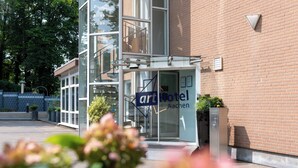 Entrada de un hotel con puerta de cristal y un letrero que dice "art Hotel Aachen".