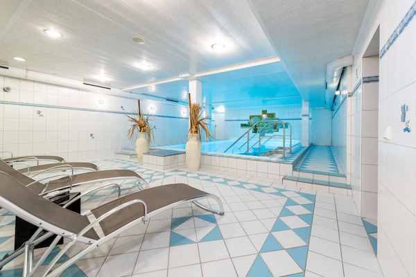 Una piscina techada, sillones reclinables de piscina