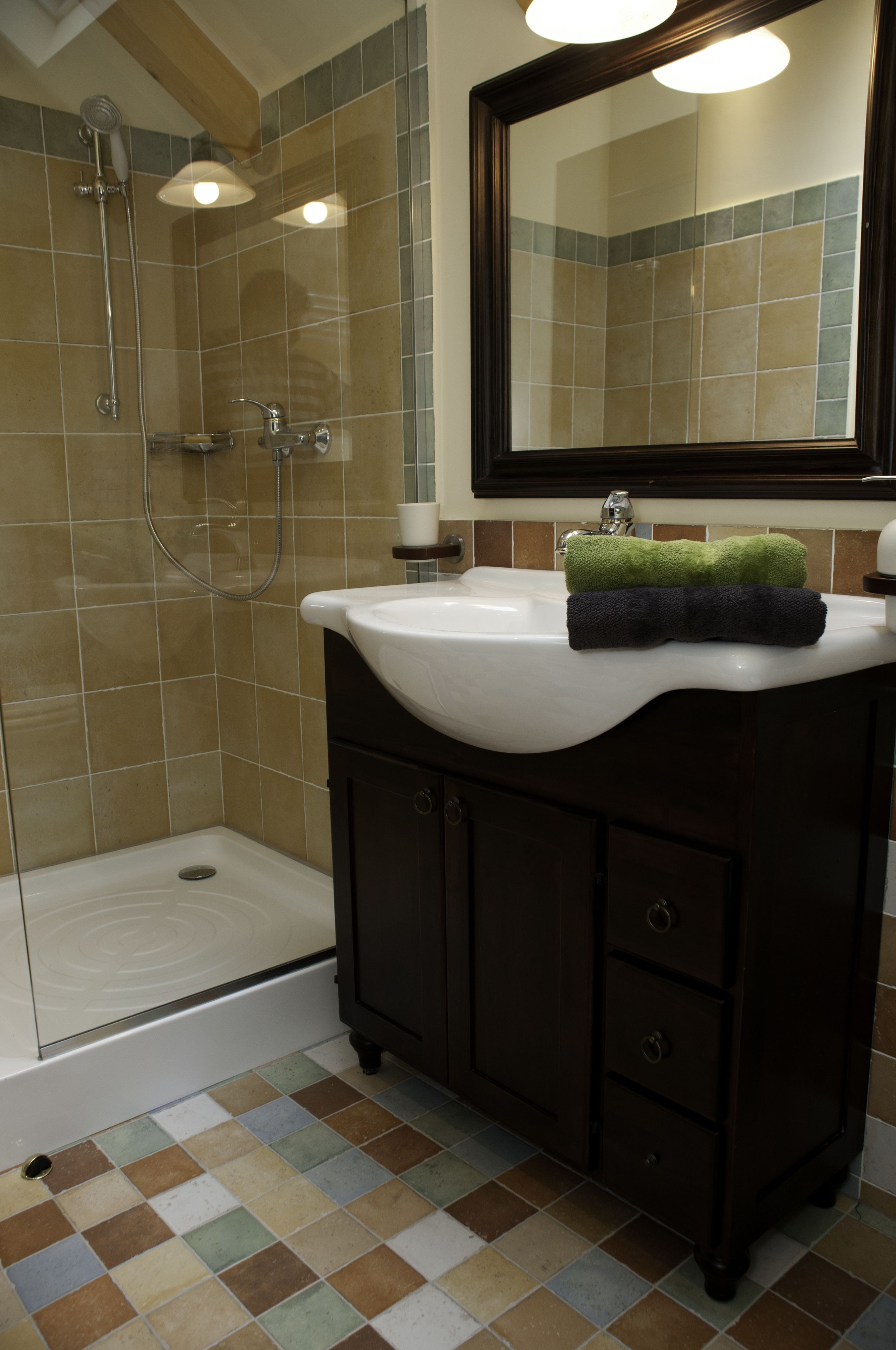 A bathroom with a shower, a sink, and a mirror.