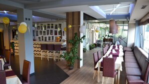 Un restaurant moderne doté d’un long comptoir, de banquettes et d’un espace bar.