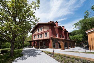 Edificio de ladrillo rojo con múltiples ventanales y un patio cubierto.